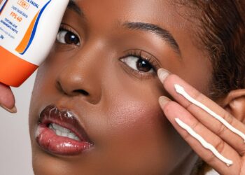 Mujer aplicando protector solar facial para proteger su piel del sol, cuidado de la piel diario