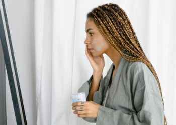 Mujer aplicando crema hidratante como parte de su rutina nocturna para la piel