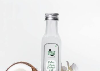 Aceite de coco para el pelo y la piel en un bote de cristal sobre fondo natural