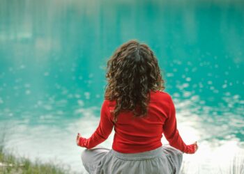 Mujer de espaldas frente al agua en una escena de calma, imagen para ilustrar el detox digital