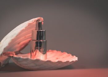 Botella de aceite de argán marroquí sobre fondo neutro para una rutina de belleza natural