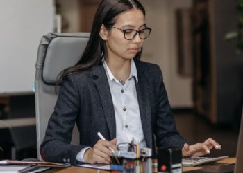 Mujer concentrada trabajando en su escritorio sin distracciones para mejorar la concentración