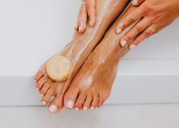 Persona lavando los pies con jabón, paso clave para eliminar los hongos en los pies