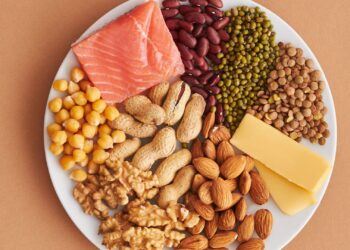Fuentes variadas de proteína en un plato para calcular cuánta proteína al día necesitas