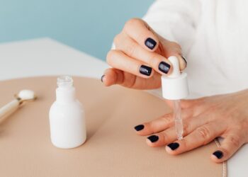 Mujer aplicando aceite de cutículas para fortalecer las uñas quebradizas