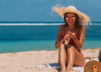 Mujer aplicándose uno de los mejores aftersun en la piel tras un día de playa