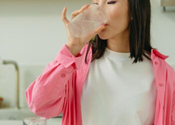 Mujer bebiendo agua para combatir la retención de líquidos con buenos hábitos de hidratación