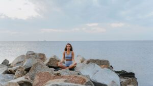 Mujer relajada practicando meditación al aire libre para bajar el cortisol alto