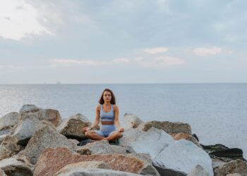 Mujer relajada practicando meditación al aire libre para bajar el cortisol alto