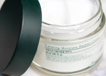 Crema reparadora sin perfume para piel sensible junto a una toalla de algodón