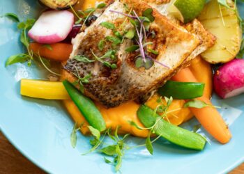 Plato de cenas saludables con salmón y verduras servido en una mesa