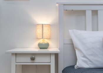 Dormitorio en penumbra con lámpara de mesilla encendida, ambiente de calma para aliviar la ansiedad nocturna