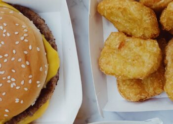 Surtido de ultraprocesados sobre una mesa: snacks salados, bollería y bebidas azucaradas