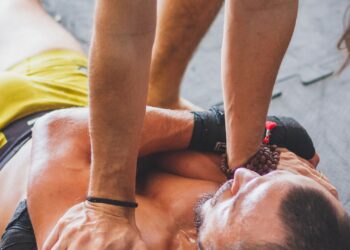 Persona aliviando las agujetas de las piernas con un rodillo de espuma sobre una esterilla