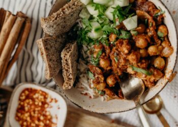 Alimentos ricos en fibra como garbanzos, verduras y semillas colocados en cuencos sobre una mesa
