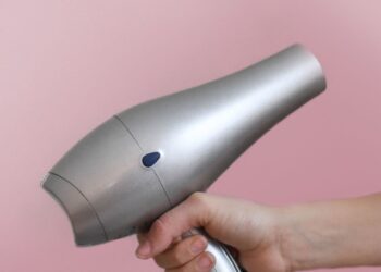 Mano sujetando un secador de pelo, guía para elegir entre los mejores secadores de pelo
