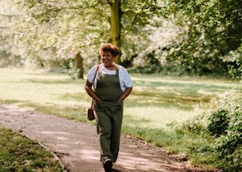 Mujer caminando al aire libre por un parque, hábito que ayuda a aumentar la dopamina de forma natural
