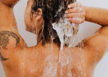 Mujer lavándose el pelo en la ducha, ilustrando cada cuánto lavarse el pelo