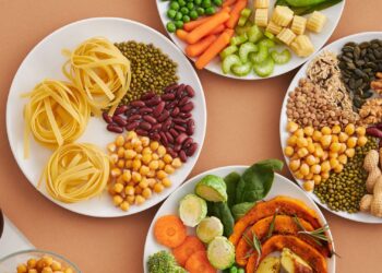 Alimentos ricos en hierro: legumbres, frutos secos y verduras en platos sobre una mesa