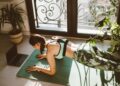 Mujer haciendo plancha abdominal sobre una esterilla en casa