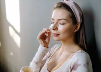 Mujer aplicando crema hidratante en el rostro para cuidar la piel seca